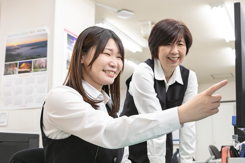 同僚とパソコンの画面を確認する様子