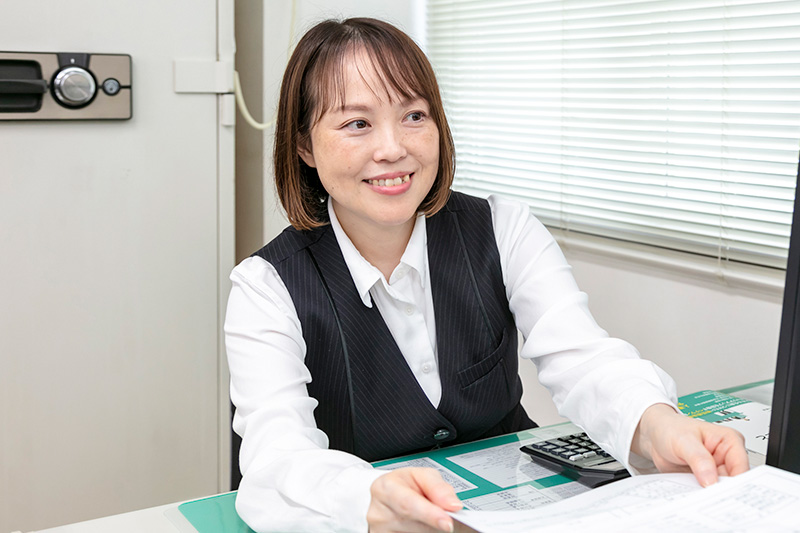 デスクで同僚とやり取りをする様子