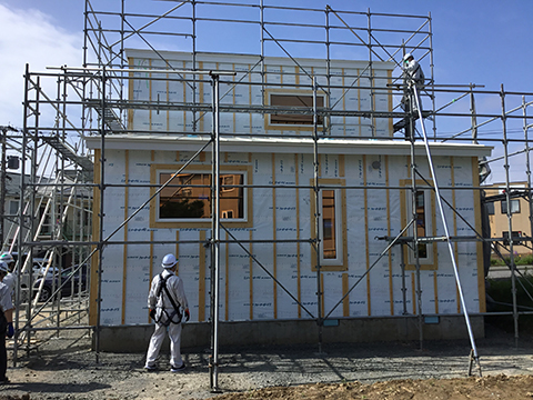 建築中の住宅を囲う足場を外側から確認する様子